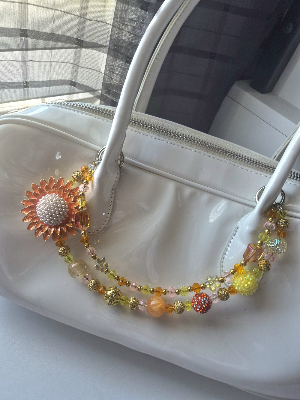 White Patent Handbag with Decorative Yellow-Orange Beaded Charm